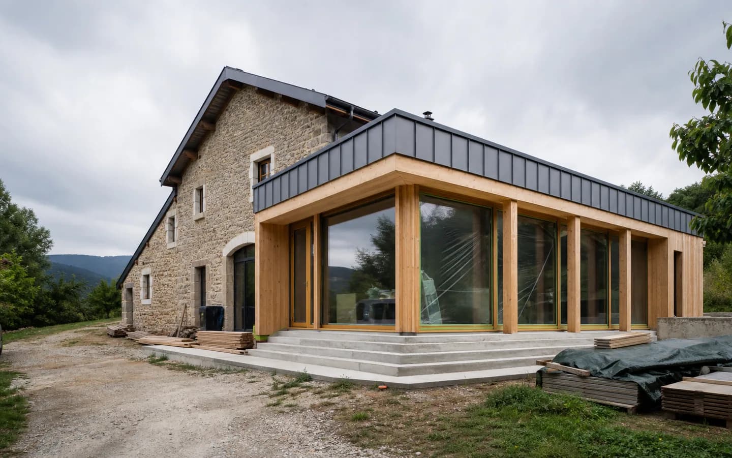 Extension contemporaine en bois attenante à une maison en pierre