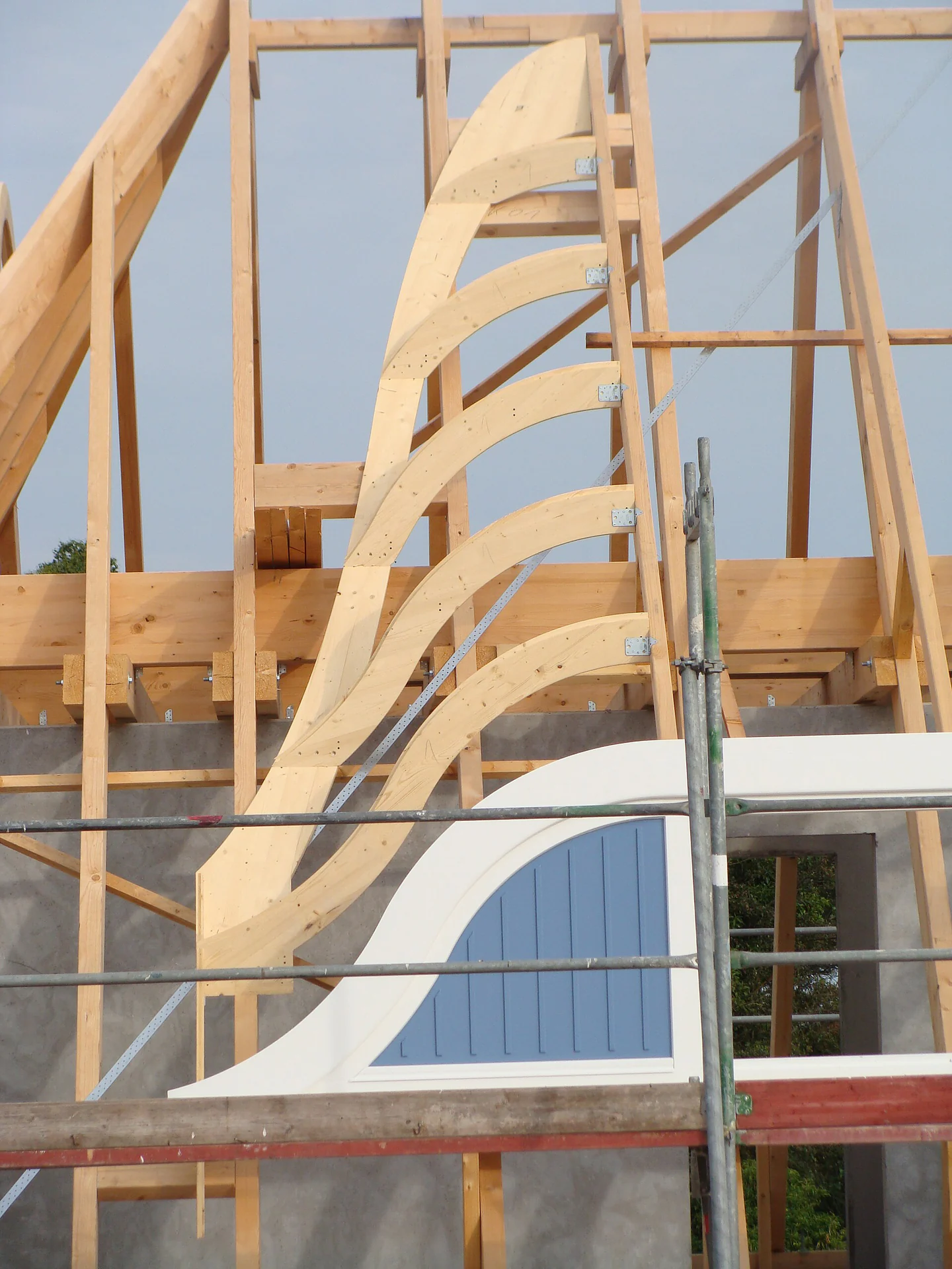 Ossature en bois sur un échafaudage Pièces courbes et montants de bois assemblés derrière un échafaudage.