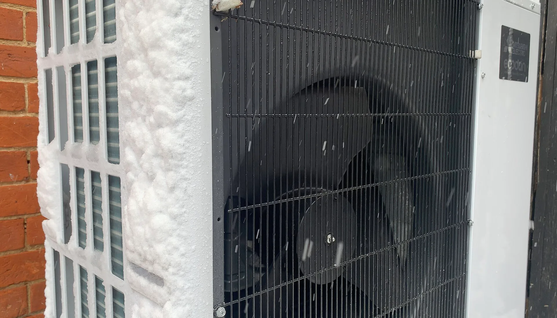 Unité extérieure avec givre sur la grille Ventilateur d'une unité extérieure dont la grille et le bord sont givrés.