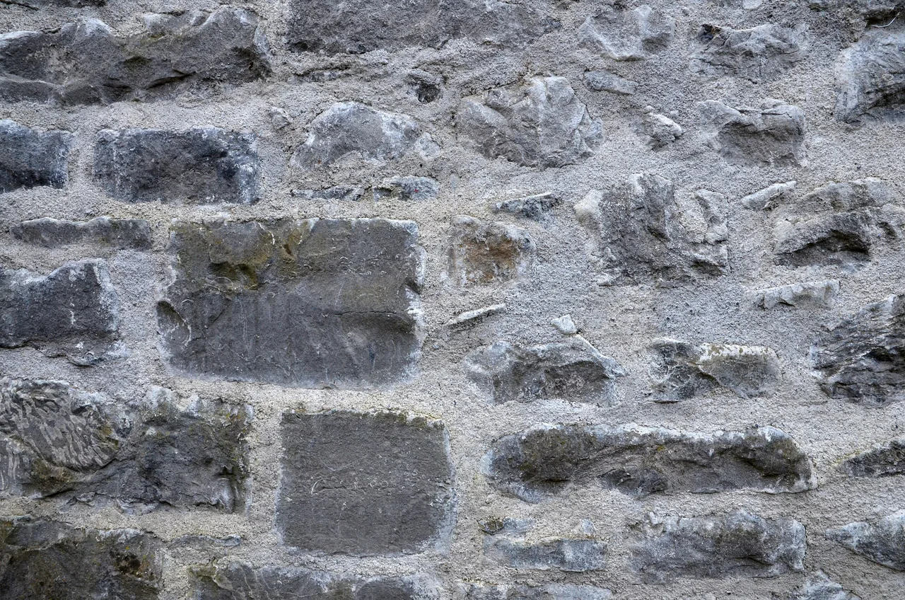 Détail des joints d'un mur en pierre Pierres grises irrégulières liées par des joints de mortier clairs.