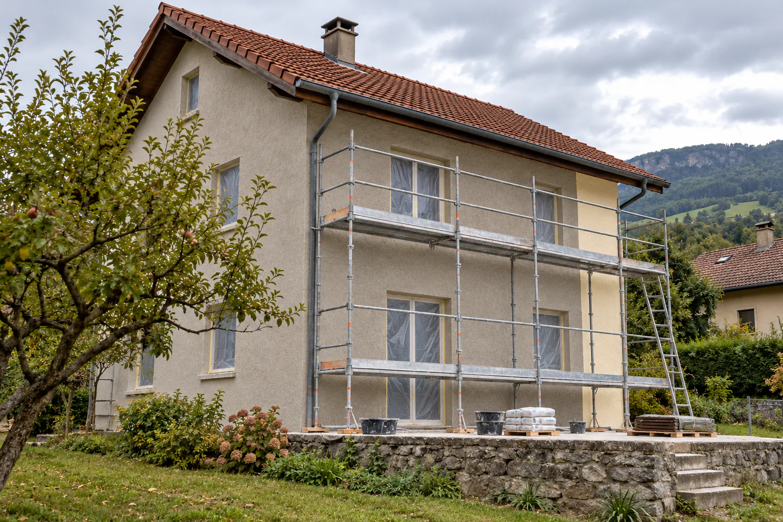 Façade de maison avec échafaudage métallique Maison claire à étage et toiture rouge avec échafaudage devant les fenêtres.