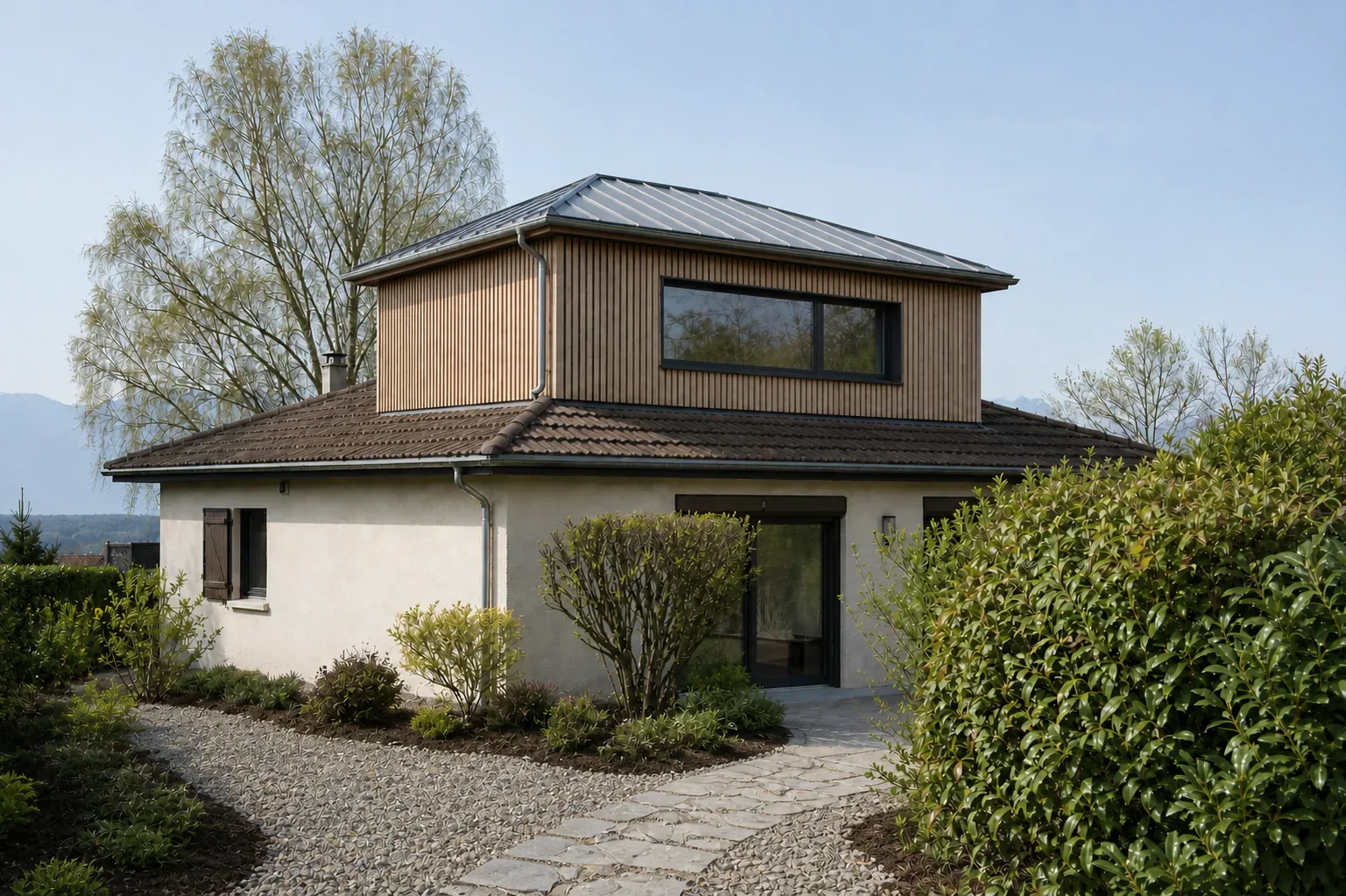 Maison avec étage en bardage bois Maison basse claire surmontée d'un volume en bois avec longue fenêtre sombre.