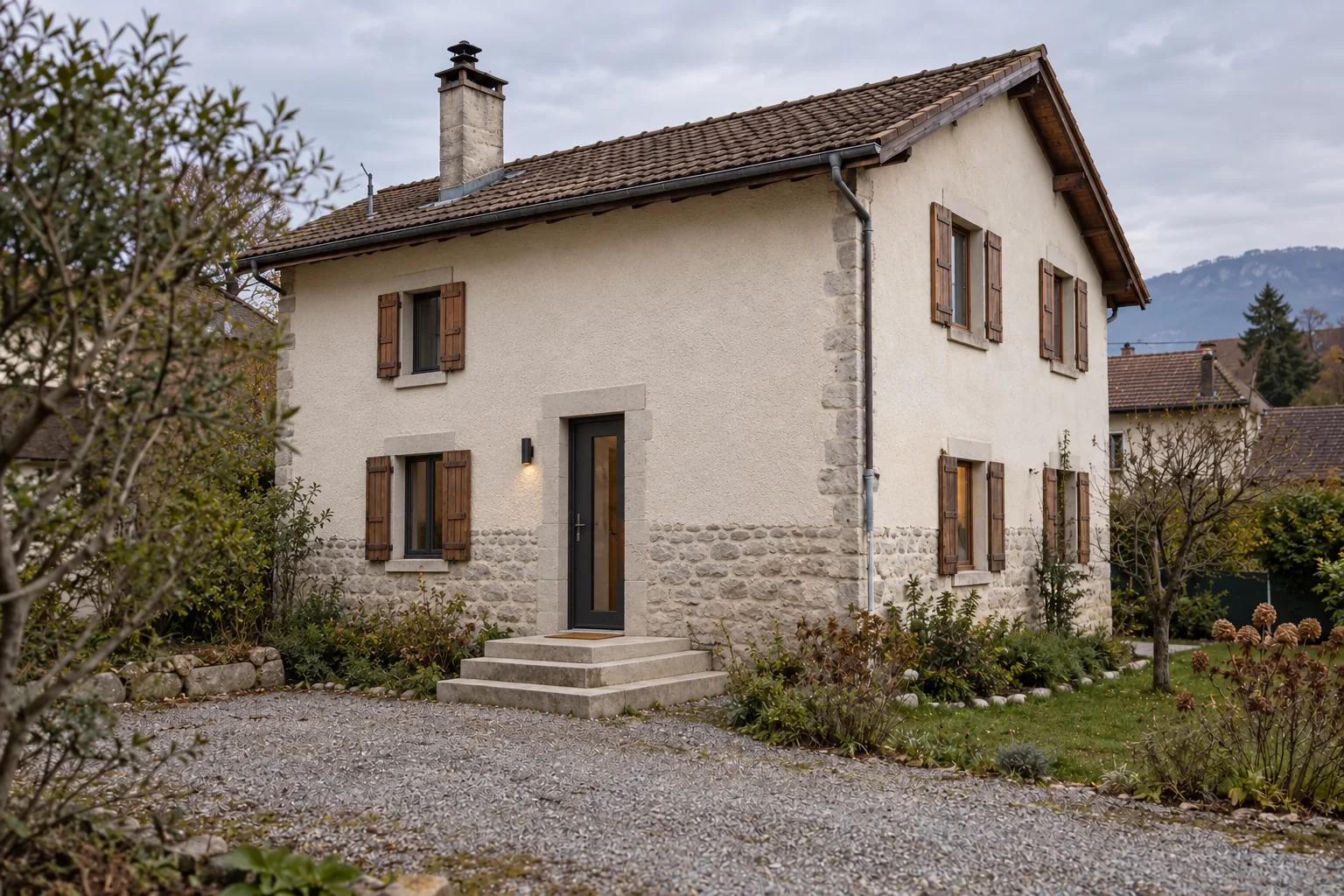 Avant : La même petite maison enduite à toiture à deux pans, avant l’ajout du petit volume d’entrée en bois.