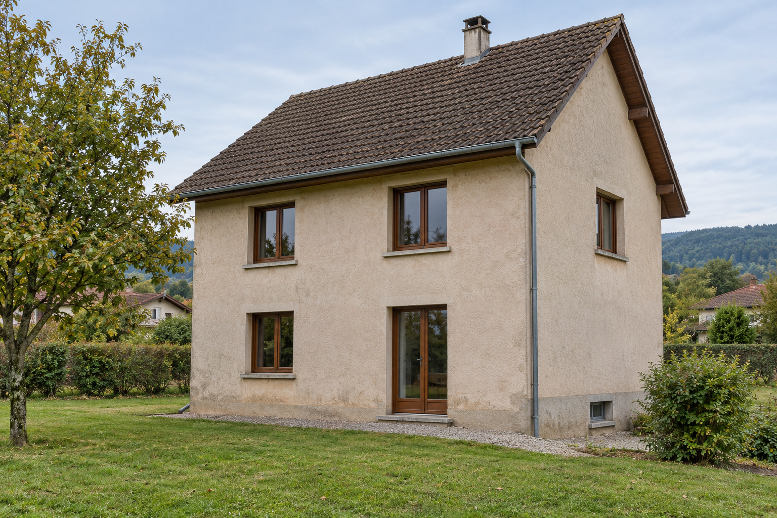Maison à étage avec toit brun, cinq baies principales en bois brun, petite baie grise de sous-sol au pignon droit et érable à gauche.